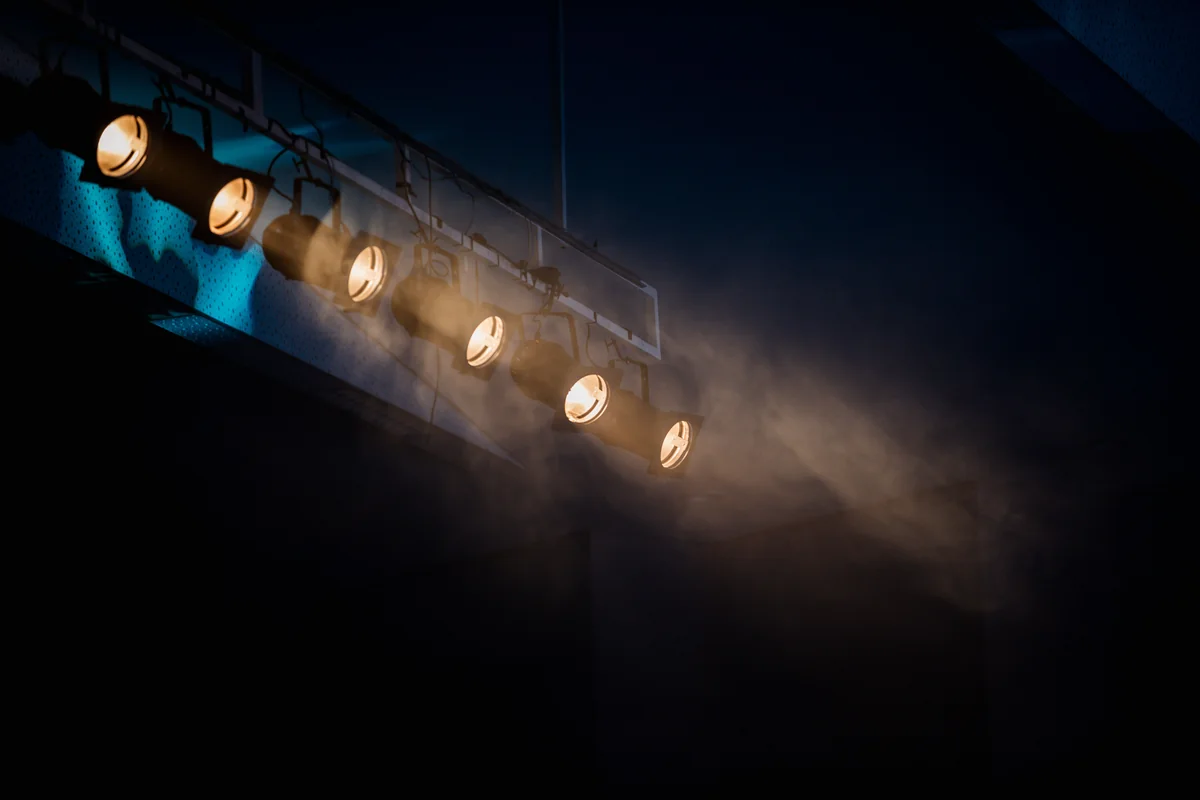 A row of spotlights hanging above a stage